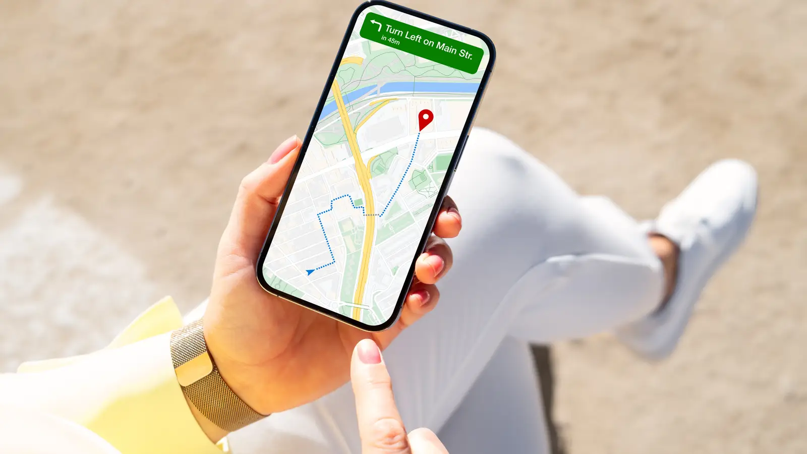 Una mano sostiene un teléfono con un mapa y direcciones en la pantalla.