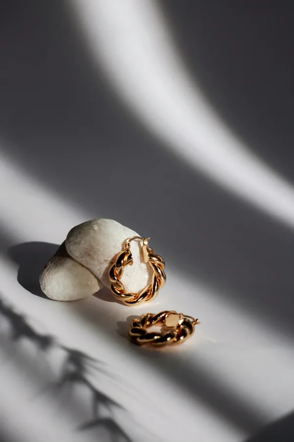 Argollas torcidas de oro sobre una piedra