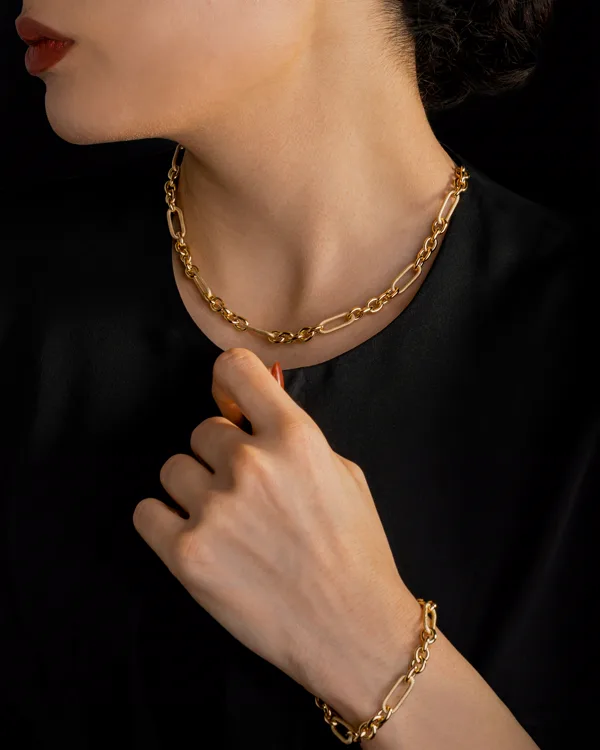 Cadena paperclip de oro sobre una blusa negra